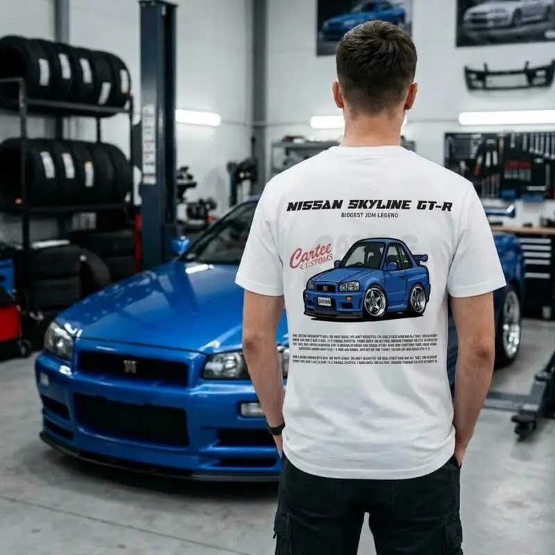 Mężczyzna w białej koszulce z nadrukiem Nissana Skyline GT-R R34 na tle niebieskiego auta
