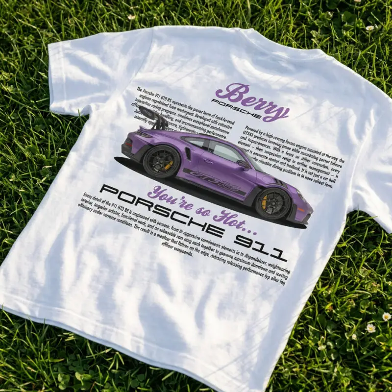 Biała koszulka z nadrukiem fioletowego Porsche 911 GT3 RS leżąca na trawie