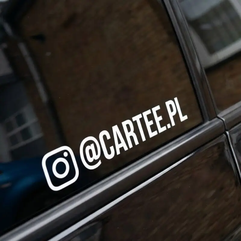 Biała naklejka z Instagramem @cartee.pl na szybie czarnego auta