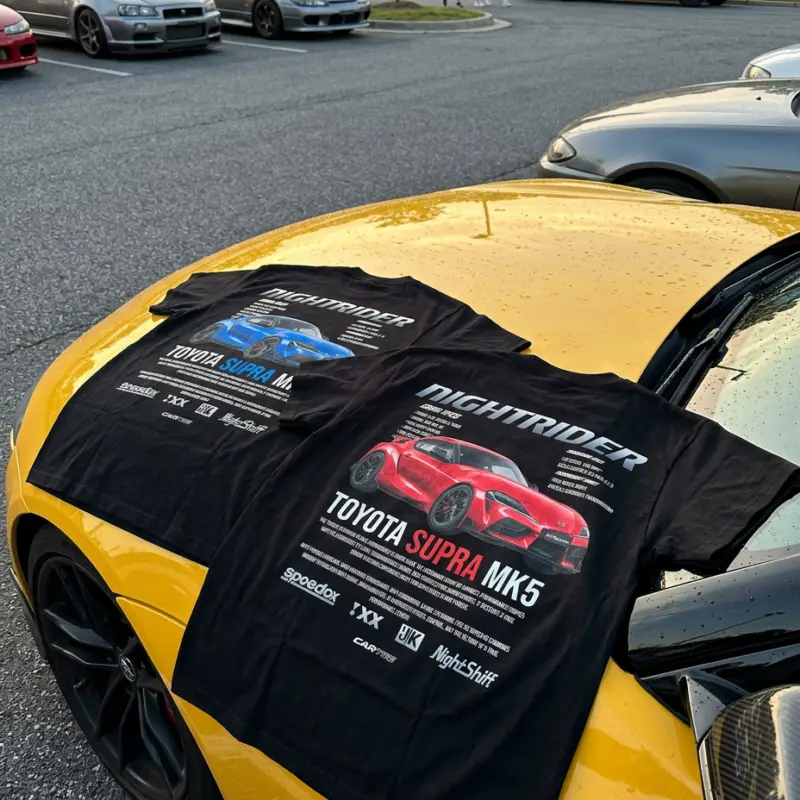 Czarne koszulki motoryzacyjne z nadrukiem Toyota Supra MK5 na masce żółtego samochodu